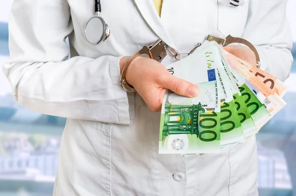 Lekarz z pieniędzy euro i kajdanki - koncepcja łapówkę — Zdjęcie stockowe