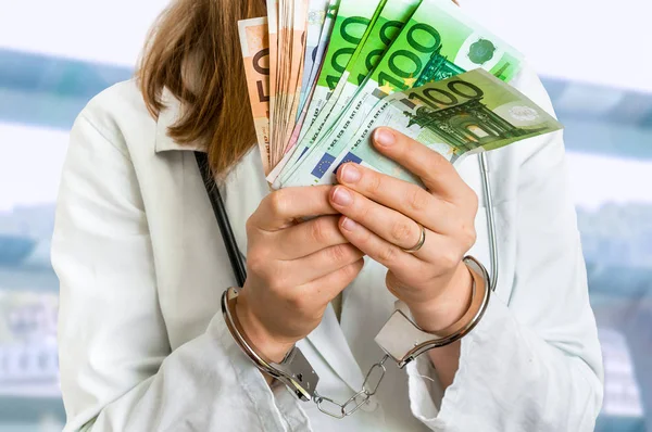 Doctor with euro money and handcuffs - bribe concept — Stock Photo, Image