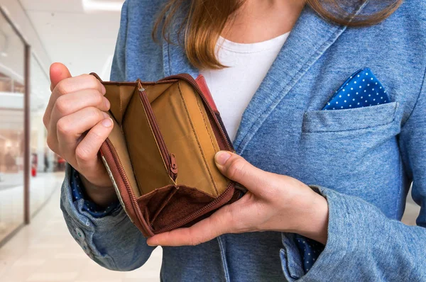 Woman holding an empty wallet in shopping centre — Stock Photo, Image