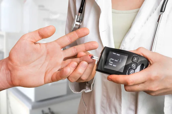 Médico comprobando el nivel de azúcar en sangre con glucosímetro — Foto de Stock