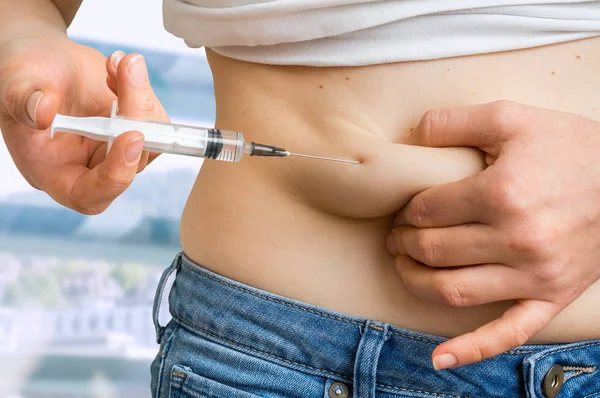 Diabetische vrouw met spuit insuline injecteren om haar buik — Stockfoto