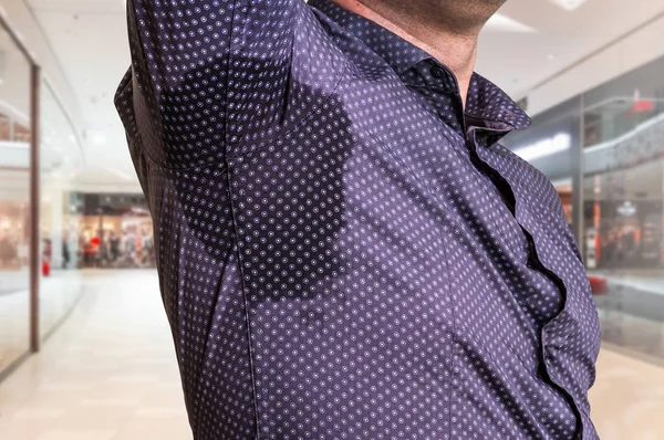 Mannen med svettning under armhåla i köpcentrum — Stockfoto