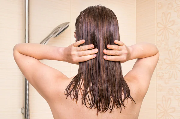 Mujer atractiva aplicando acondicionador en su cabello en el baño —  Fotos de Stock