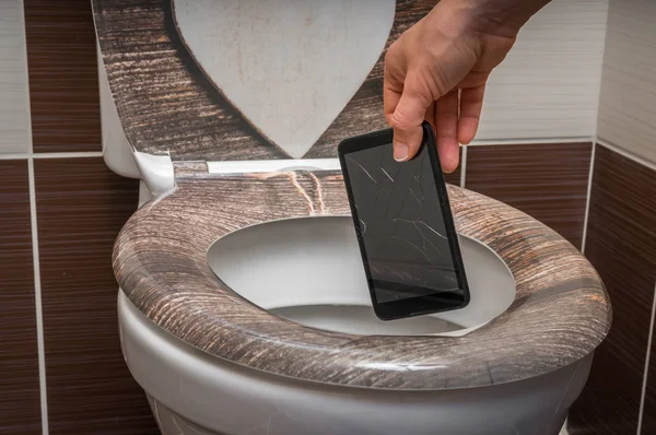 Femme jetant téléphone portable dans la cuvette des toilettes — Photo