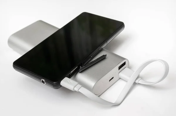 Charging smartphone from white powerbank — Stock Photo, Image