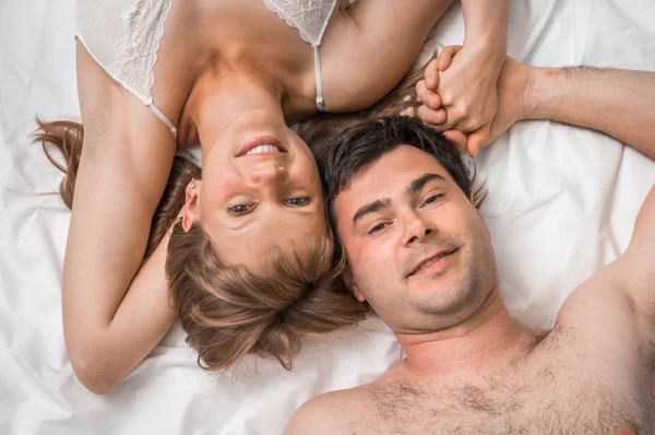 Bovenaanzicht van een liefdevol paar samen in bed liggen — Stockfoto