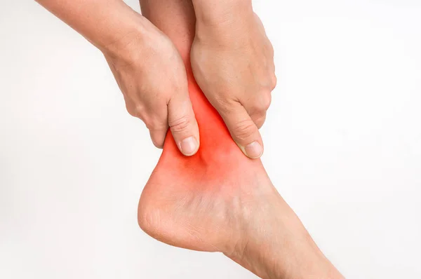Mulher com dor no tornozelo segurando sua perna dolorida — Fotografia de Stock