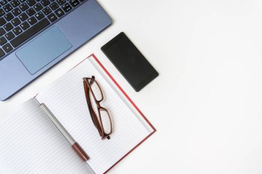 İşyeri dizüstü bilgisayar ve Beyaz ahşap masa üstünde smartphone