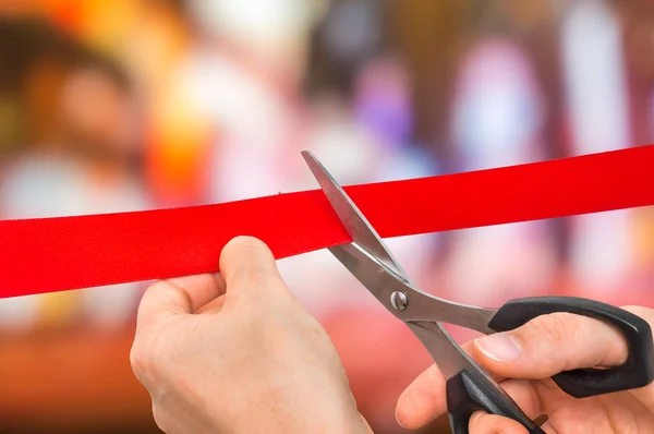 Hand met schaar snijden rood lint - openingsceremonie — Stockfoto