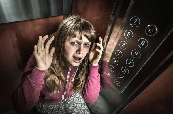 Schockierte Frau mit Klaustrophobie im fahrenden Fahrstuhl — Stockfoto
