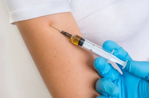 Médico que administra a injeção da vacina no ombro feminino — Fotografia de Stock