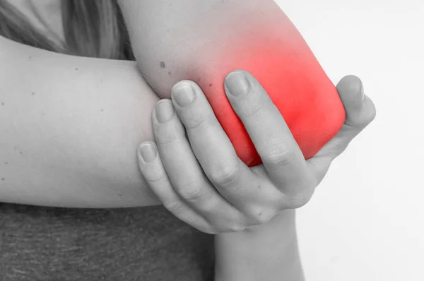 Kvinna med armbågen smärta håller sin värkande arm — Stockfoto
