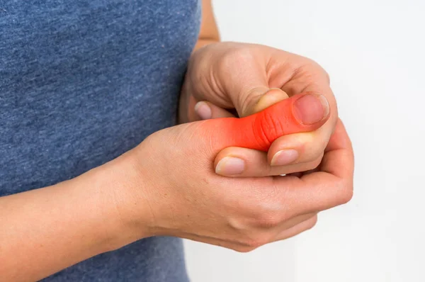 Mujer con dolor en el dedo sostiene su dedo dolorido —  Fotos de Stock