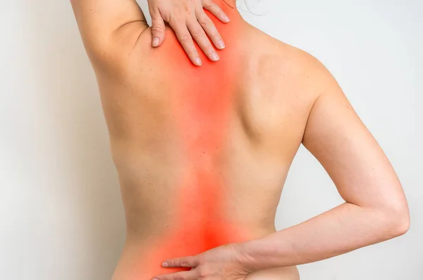 Mujer con dolor en la columna vertebral está sosteniendo su dolor de espalda — Foto de Stock