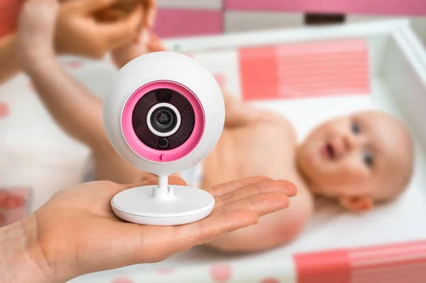 Moeder houdt baby monitor camera voor de veiligheid van haar baby — Stockfoto