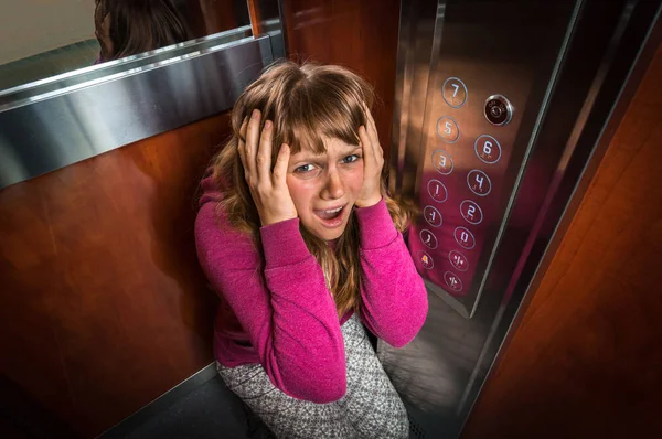 Schockierte Frau mit Klaustrophobie im fahrenden Fahrstuhl — Stockfoto