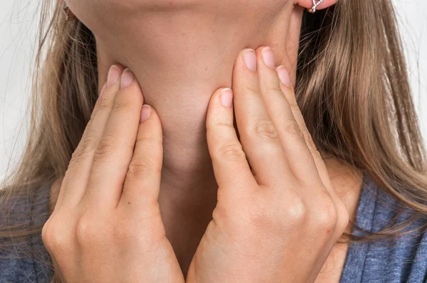 Vrouw met zere keel houdt haar pijnlijke keel — Stockfoto