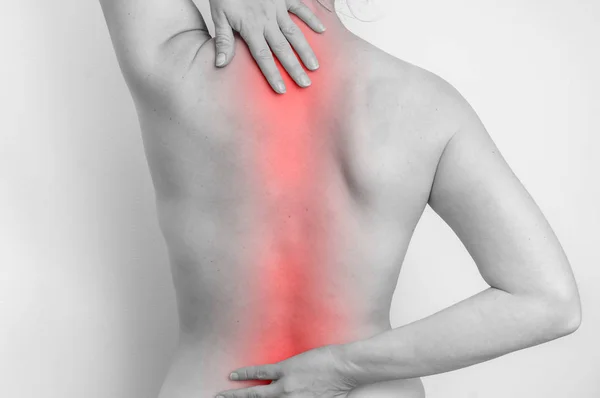 Mujer con dolor en la columna vertebral está sosteniendo su dolor de espalda — Foto de Stock