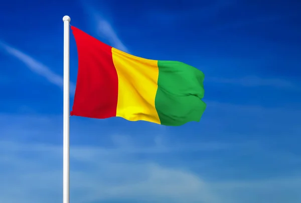 在蓝天背景下挥舞着几内亚国旗 — 图库照片