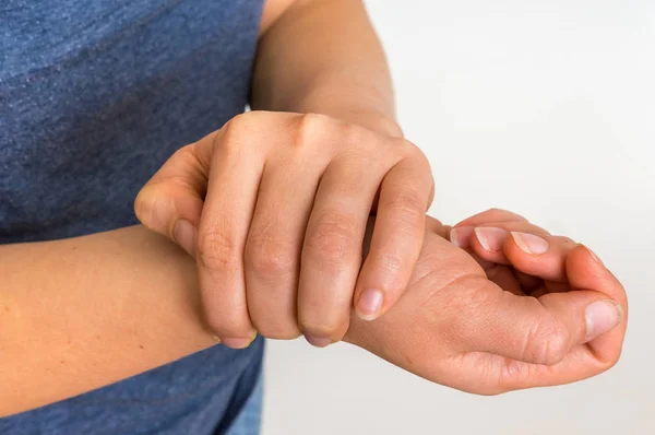Женщина с болью в запястье держит свою больную руку — стоковое фото