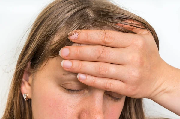 Mujer con dolor de cabeza sostiene su frente dolorida — Foto de Stock