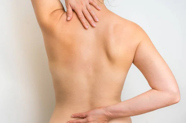 Жінка з болем у хребті тримає її спину — стокове фото
