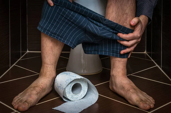 L'homme souffre de diarrhée est assis sur la cuvette des toilettes — Photo