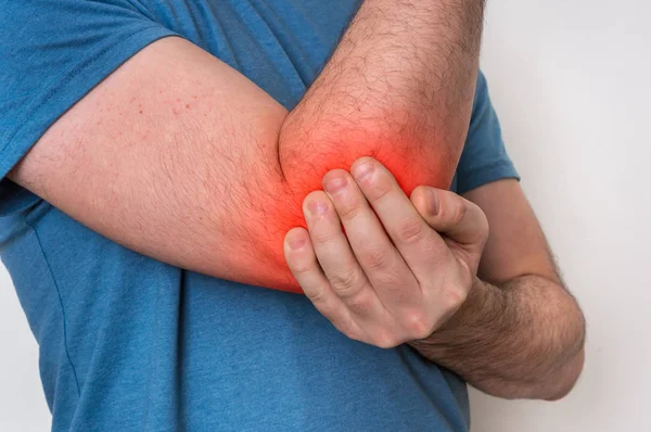 El hombre con dolor de codo sostiene su brazo dolorido —  Fotos de Stock
