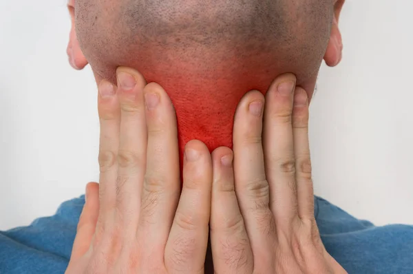Mann mit Halsschmerzen hält seinen schmerzenden Hals — Stockfoto