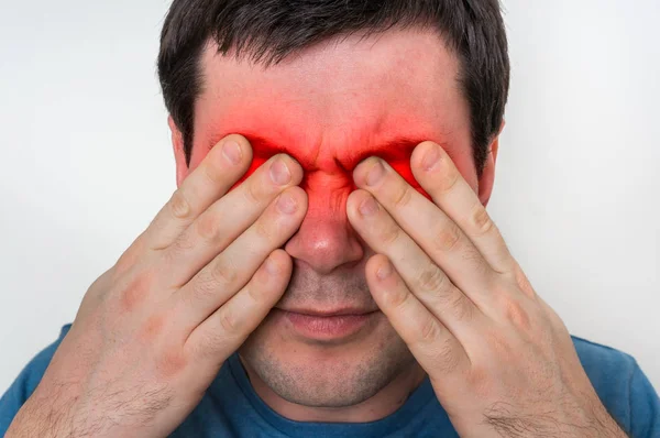 El hombre con ojos el dolor sostiene sus ojos doloridos —  Fotos de Stock