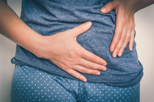 Mujer con dolor de estómago está sosteniendo su dolor de vientre — Foto de Stock