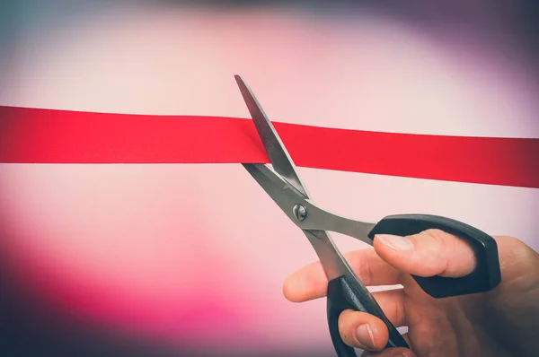 Hand met schaar snijden rood lint - openingsceremonie — Stockfoto