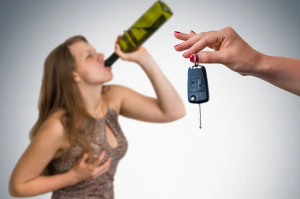 Mulher bebendo álcool e seu amigo mostrando chaves do carro — Fotografia de Stock