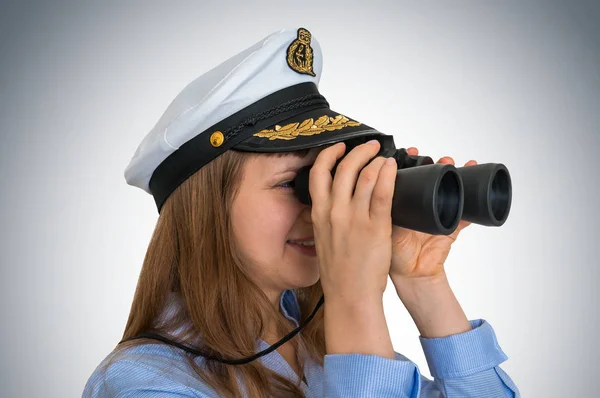 Happy female captain looks through a binoculars — Stock Photo, Image