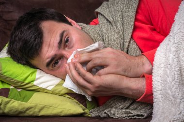 Grip olan ve onun burun akıntısı üfleme hasta adamı