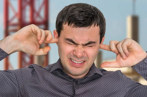 Mann schließt Ohren mit Fingern, um sich vor lautem Lärm zu schützen — Stockfoto