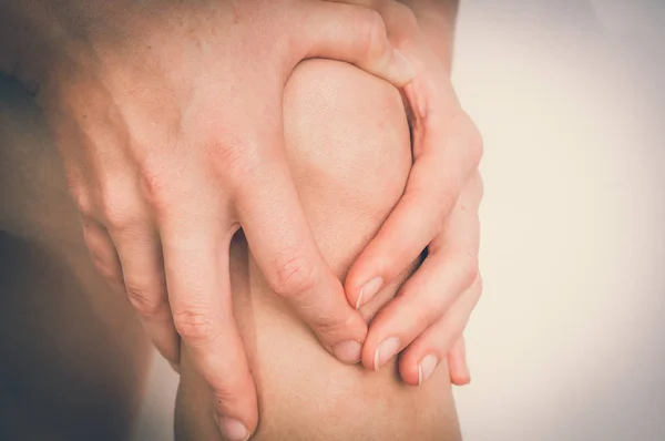 Γυναίκα με πόνο στο γόνατο κρατώντας το πόδι που πονά — Φωτογραφία Αρχείου