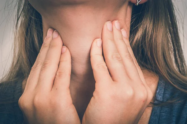 Vrouw met zere keel houdt haar pijnlijke keel — Stockfoto