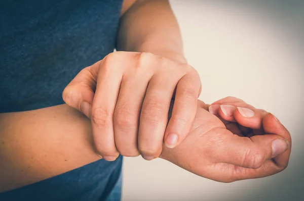 Kvinna med smärta i handleden håller sin värkande hand — Stockfoto