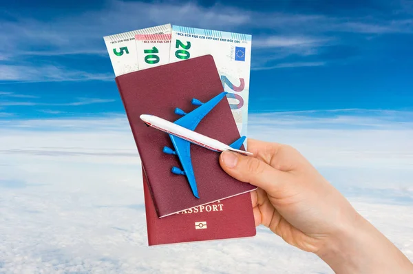 Airplane, passport and money in female hand - travelling concept — Stock Photo, Image