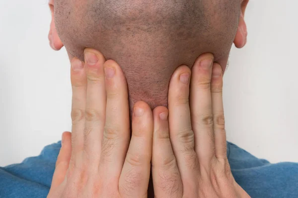 Muž s krku bolí drží jeho bolavé hrdlo — Stock fotografie