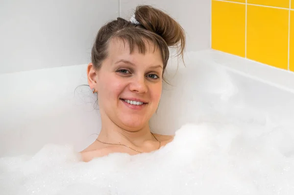 Hermosa mujer joven se relaja en el baño con espuma —  Fotos de Stock