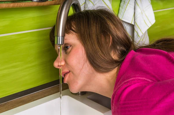 Attractive woman drinking fresh water from a faucet — Stock Photo, Image