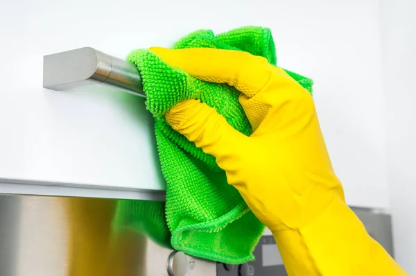 Mão na luva com pano verde está limpando alças de aço inoxidável — Fotografia de Stock