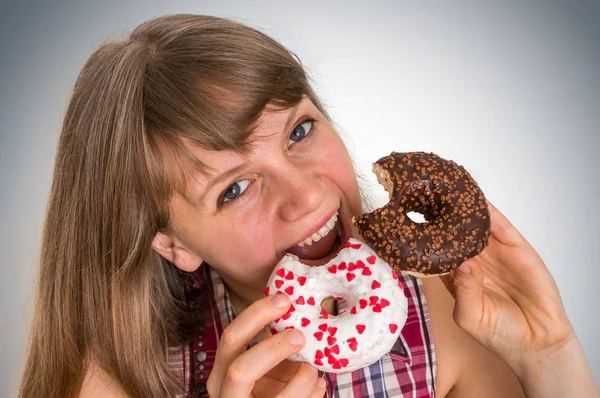Привлекательная женщина ест вкусные пончики — стоковое фото