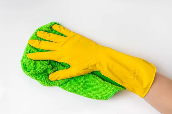 Hand in glove with green rag is wiping white door in kitchen — Stock Photo, Image