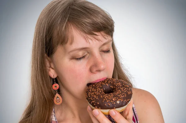Привлекательная женщина ест вкусный пончик — стоковое фото