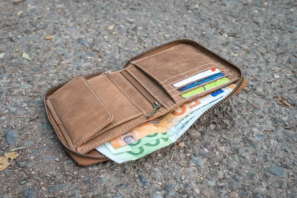 Lost leather wallet with money on street
