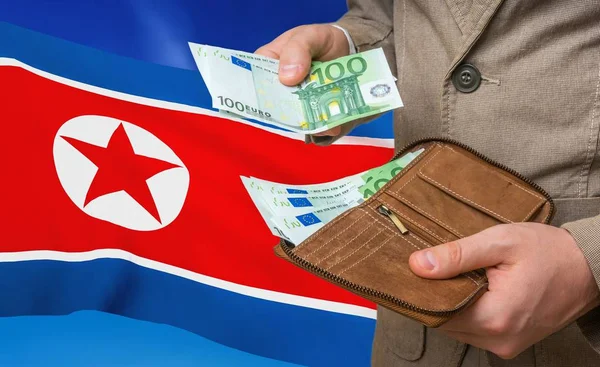 Investing money to North Korea. Rich man with a lot of money.