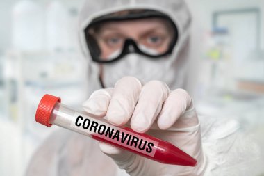 Bilim adamı Coronavirus Covid-19 üzerinde test tüpü tutuyor.